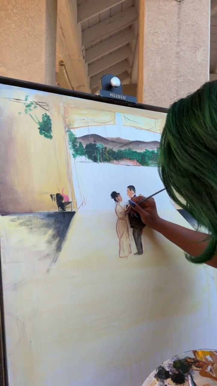 Chaleuh painting the anniversary couple onto the canvas during the celebration