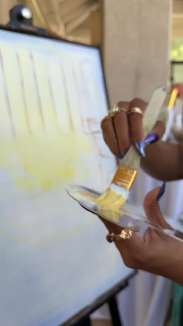 Close-up of Chaleuh's brush laying the first golden tones onto a blank canvas