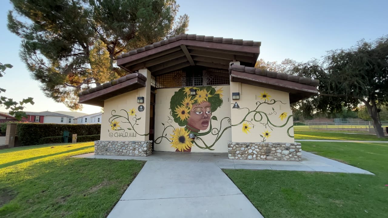 Walking up to a sunflower portrait mural painted across a park building